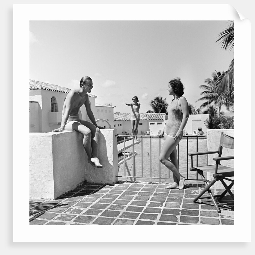 1930s man woman wearing bathing suits on terrace overlooking swimming pool woman on diving board by Anonymous