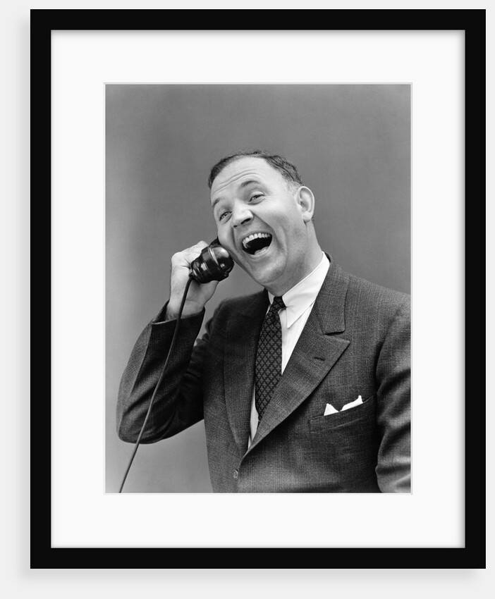 1930s man in suit laughing talking on telephone by Anonymous