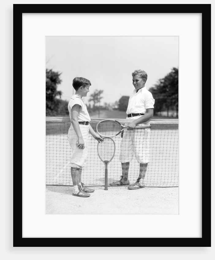 1920s 1930s two boys tennis match holding rackets measuring net height by Anonymous