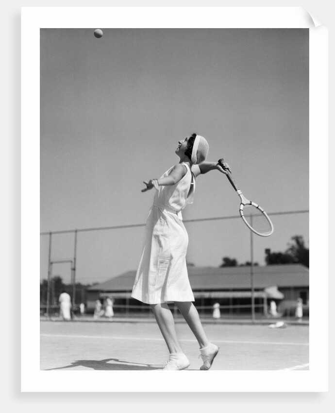 1930s woman playing tennis about to hit ball with racket by Anonymous