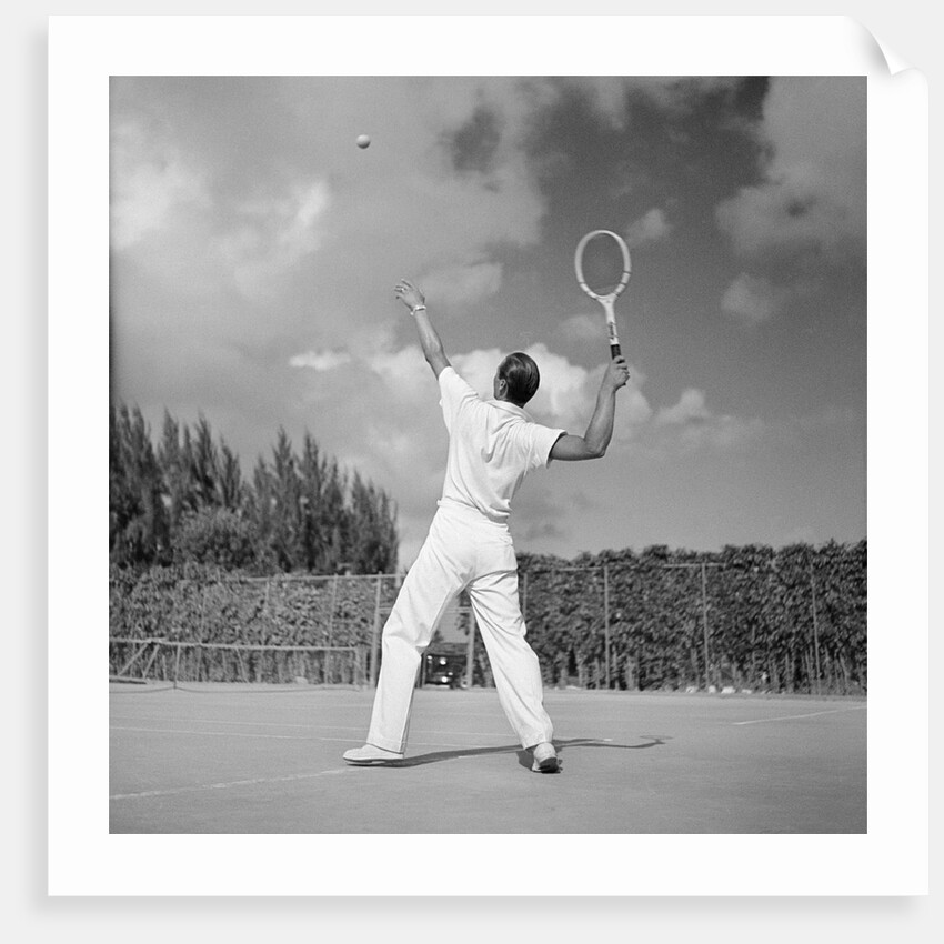 1930s back view of man playing tennis about to hit the ball summer outdoor by Anonymous