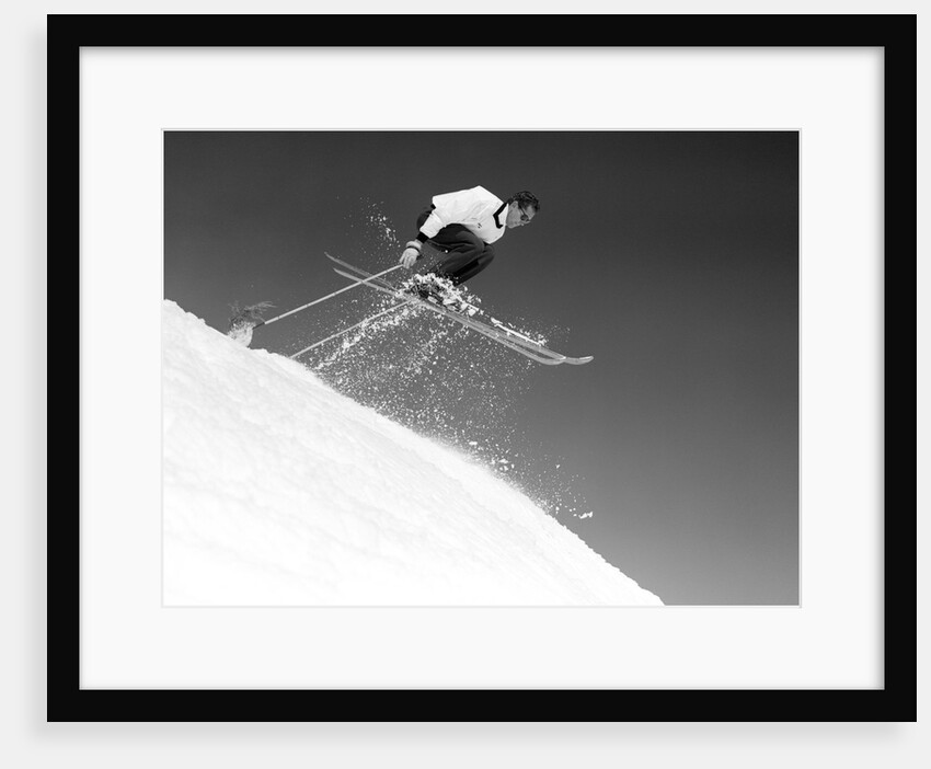 1950s man skier skiing down slope jumping into air by Anonymous
