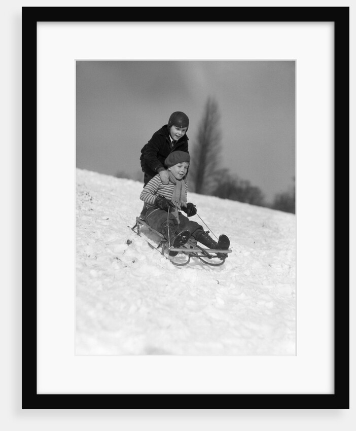 1930s two boys sledding outside in snow by Anonymous
