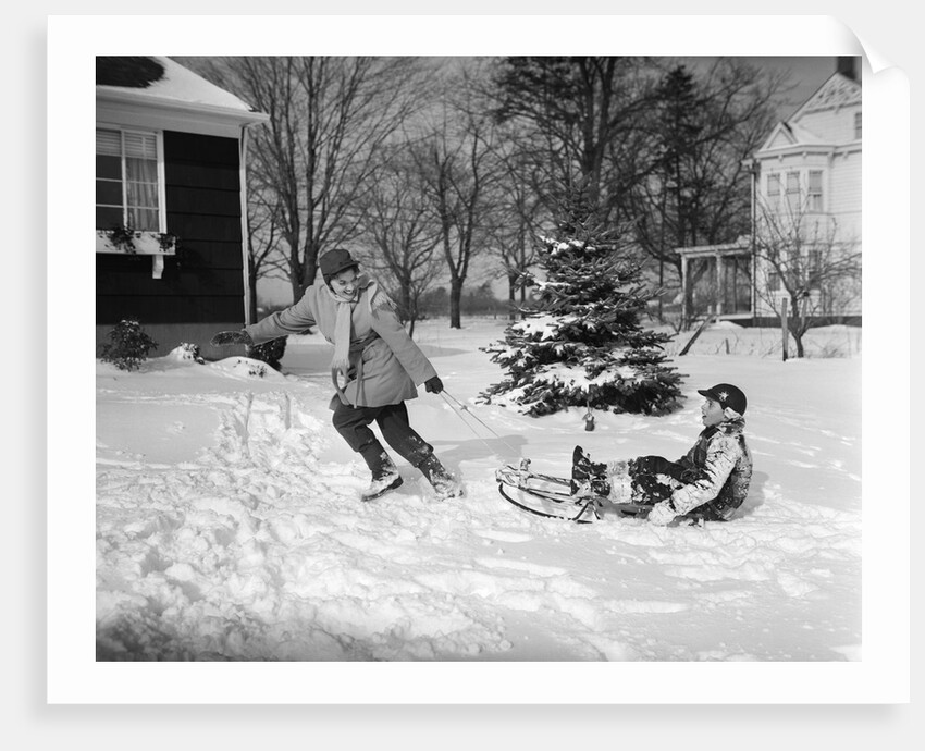 1950s woman mother pulling boy son on sled in winter by Anonymous