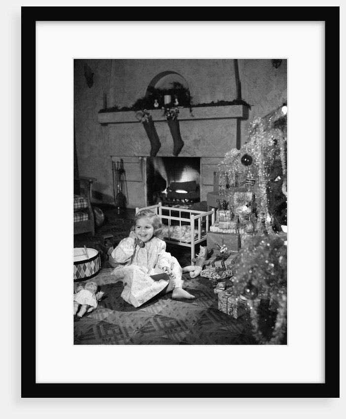 1950s smiling little girl christmas tree talking on toy telephone by Anonymous