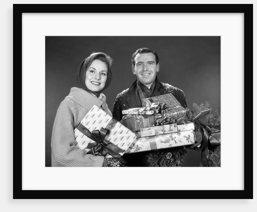 1960s smiling couple man and woman holding wrapped christmas presents and packages by Anonymous
