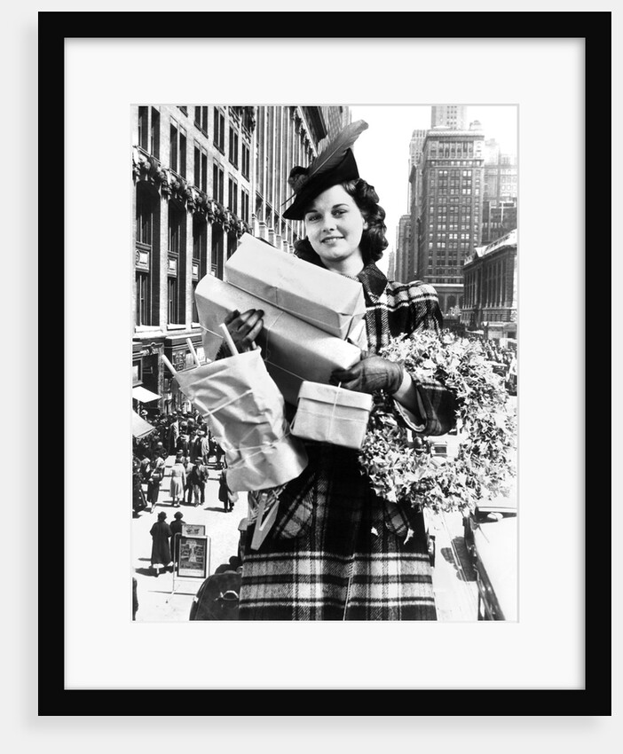 1930s 1940s woman looking at camera arms full with christmas shopping packages & wreath composite with street scene by Anonymous