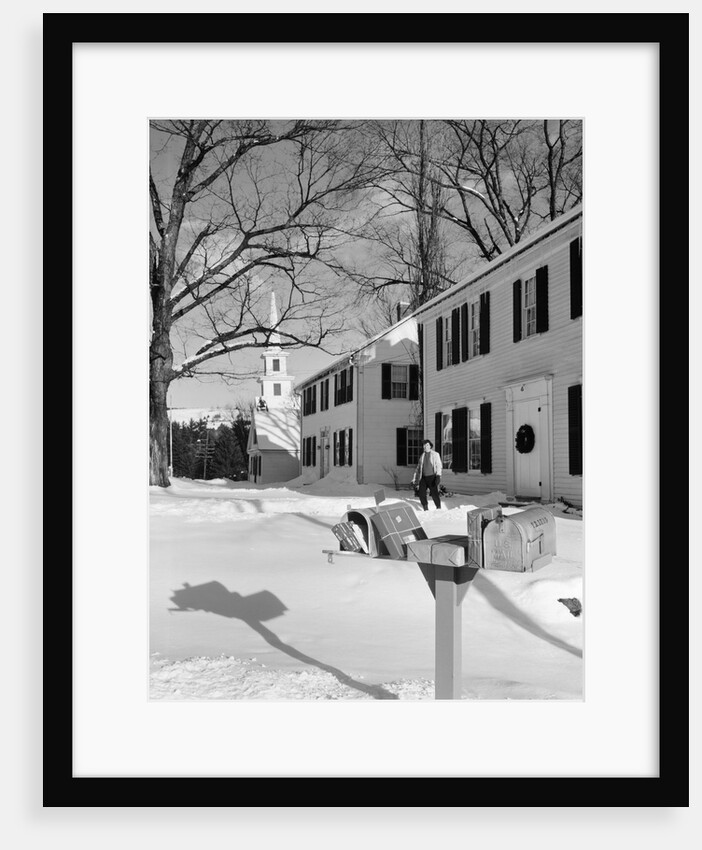 1960s woman walking to rural mailbox in front of home in snow piled with christmas packages by Anonymous