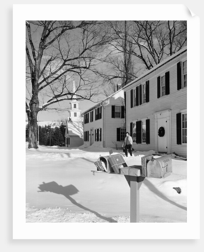 1960s woman walking to rural mailbox in front of home in snow piled with christmas packages by Anonymous