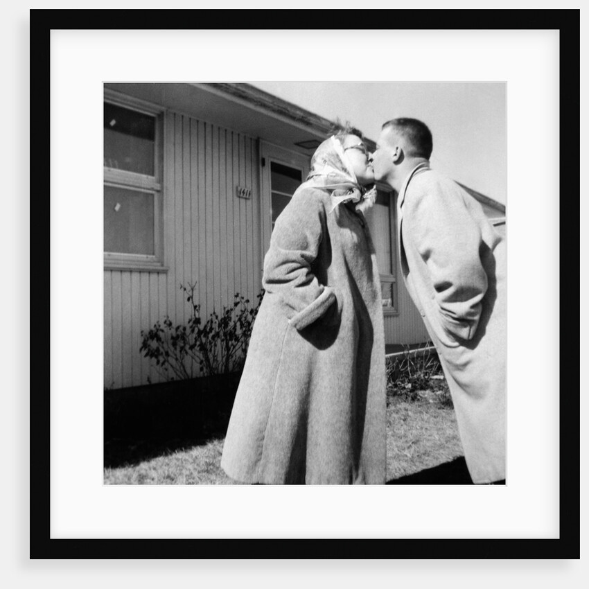 Young husband and wife kiss, ca. 1955. by Anonymous