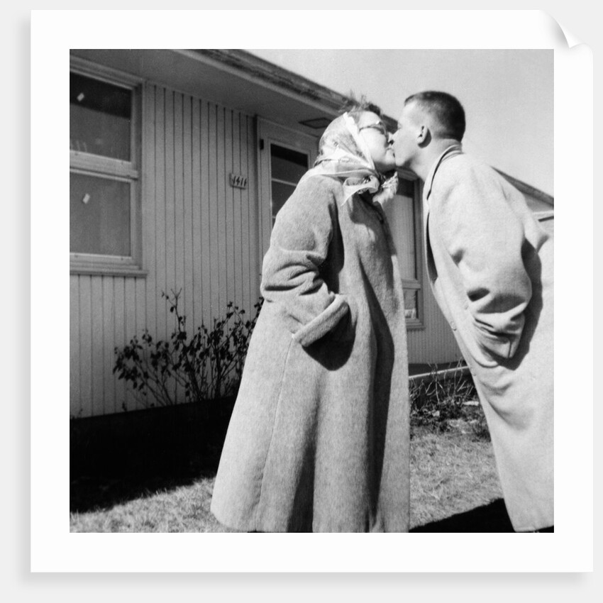 Young husband and wife kiss, ca. 1955. by Anonymous