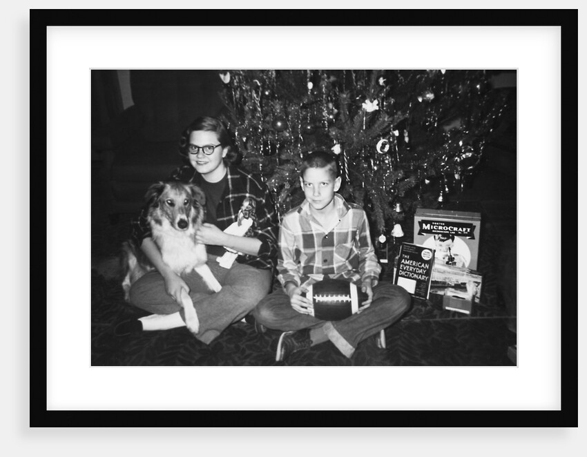 Brother and sister pose by the Christmas tree, ca. 1960 by Anonymous