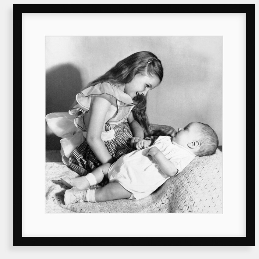 Big sister looks down on her baby brother, ca. 1948 by Anonymous