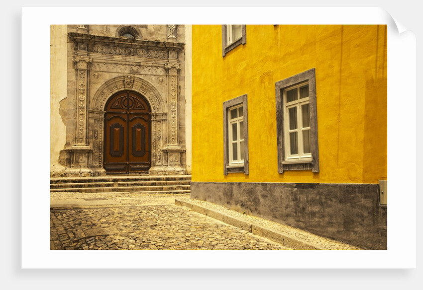 A street in Tavira leading to the entrance of a church by Anonymous