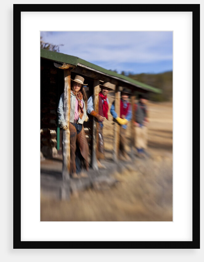Cowgirls and cowboys outside a cabin by Anonymous