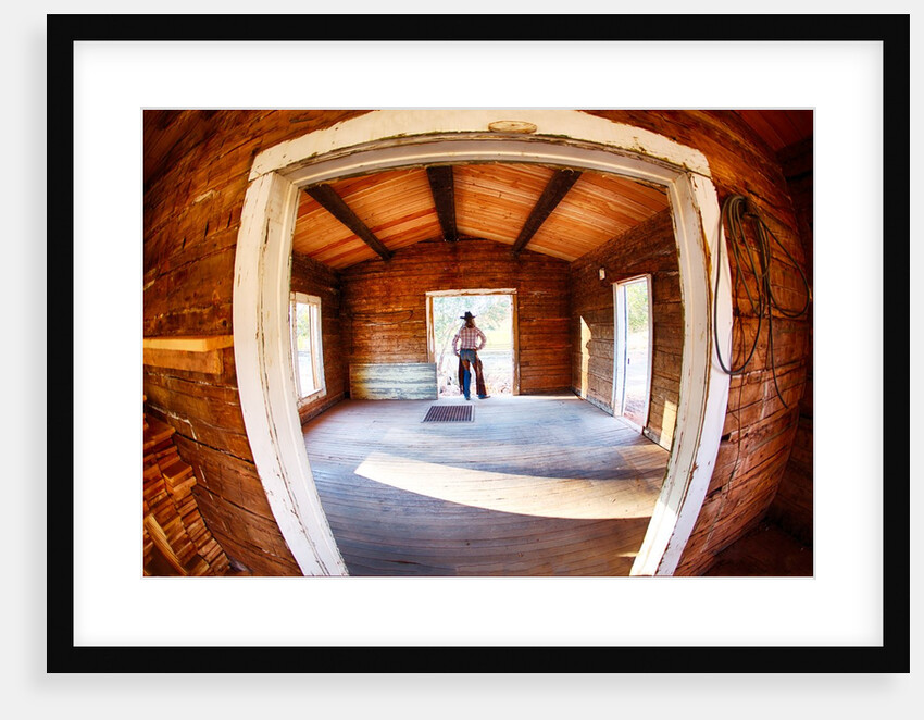 Cowgirl in doorway of old cabin by Anonymous