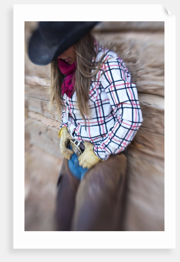 Cowgirl outside cabin by Anonymous