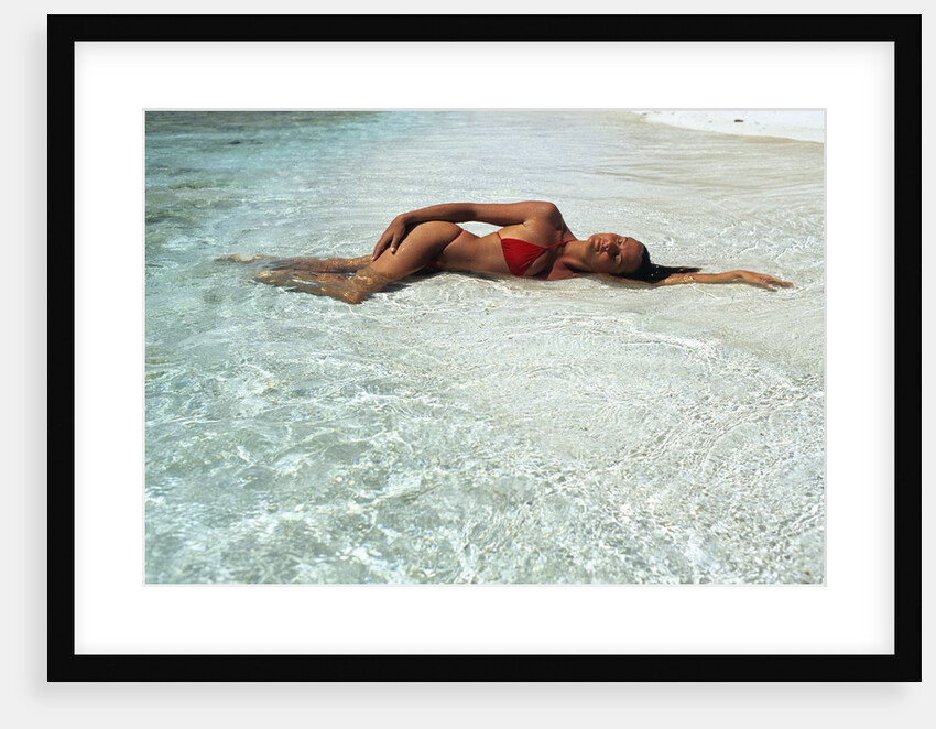 1990s Woman In Red Bikini Lying In Shallow Water On The Beach by Anonymous