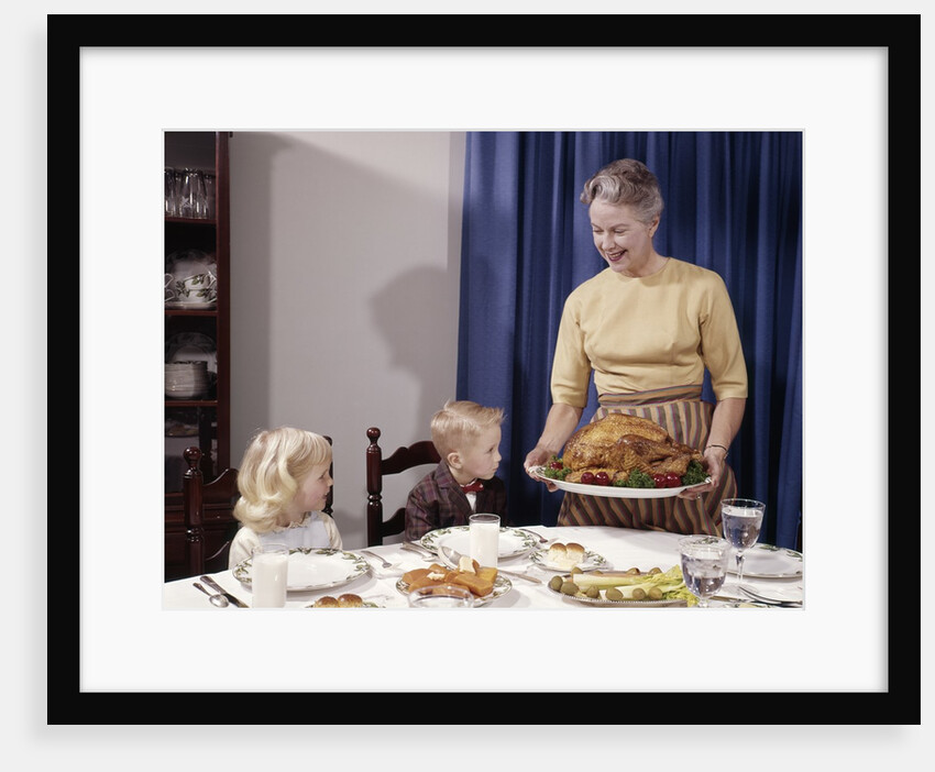 1960s Grandmother Presenting Roasted Turkey To Children At Dining Room Table by Anonymous