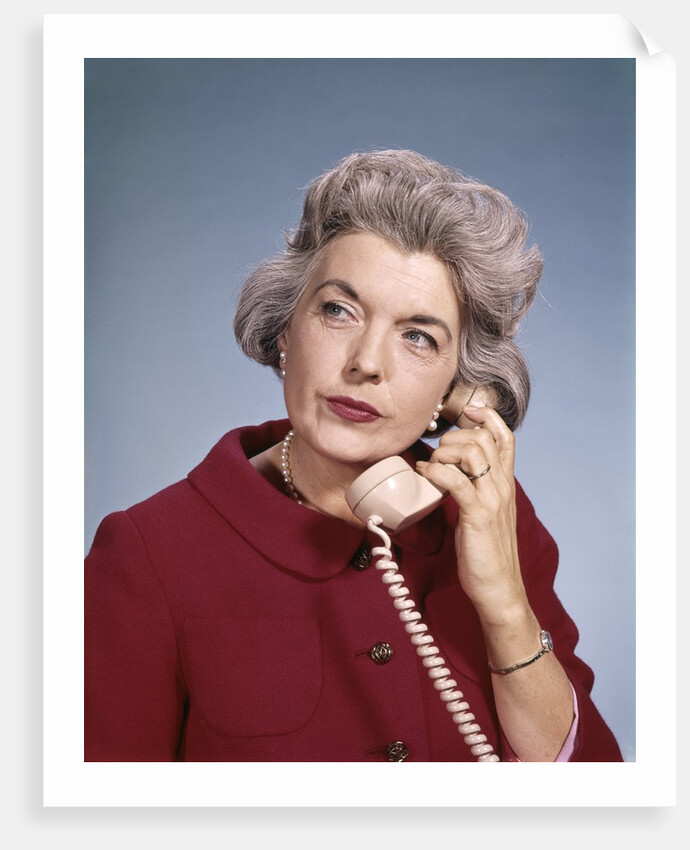 1960s Senior Middle Aged Woman Red Blouse Serious Expression Talking On Telephone by Anonymous