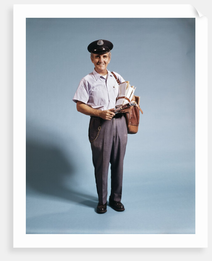 1970s Standing Full Length Portrait Of Middle Aged Mailman Carrying Mail Bag Wearing Uniform by Anonymous