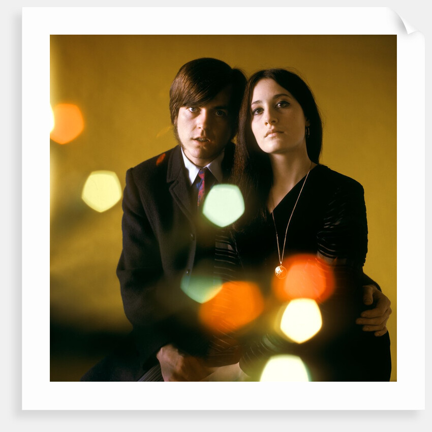 1960s 1970s Young Couple Man Woman Head To Head Dressed In Black Look At Camera Mod Style Serious Expression Blur Lights by Anonymous