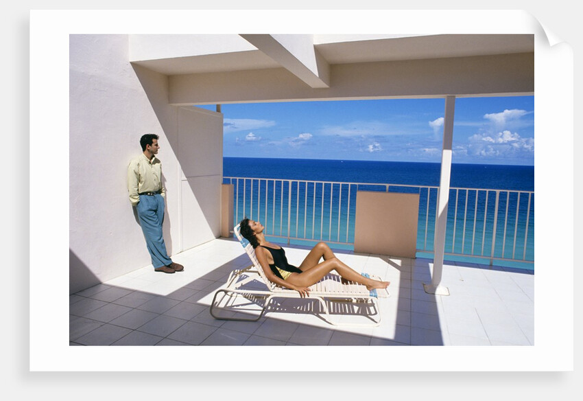 1990s Man And Woman On Sunny Deck Balcony Overlooking The Ocean by Anonymous