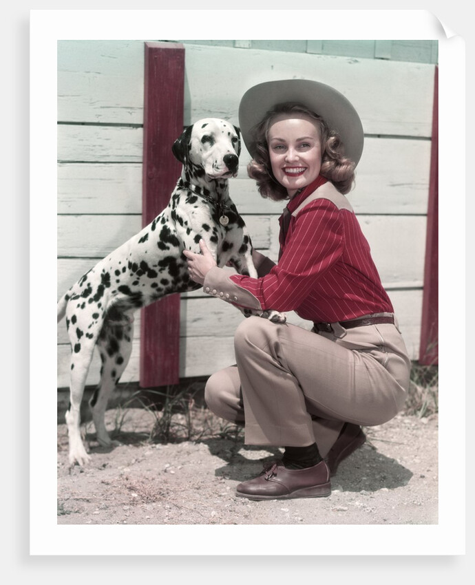 1940s 1950s Smiling Woman Wearing Western Cowgirl Outfit Kneeling Petting Dalmatian Dog by Anonymous