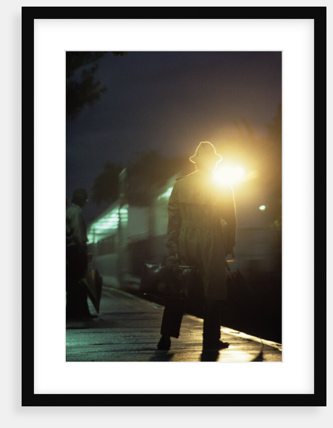 1970s 1980s Anonymous Man Commuter Waiting For Train Silhouetted By Bright Light by Anonymous