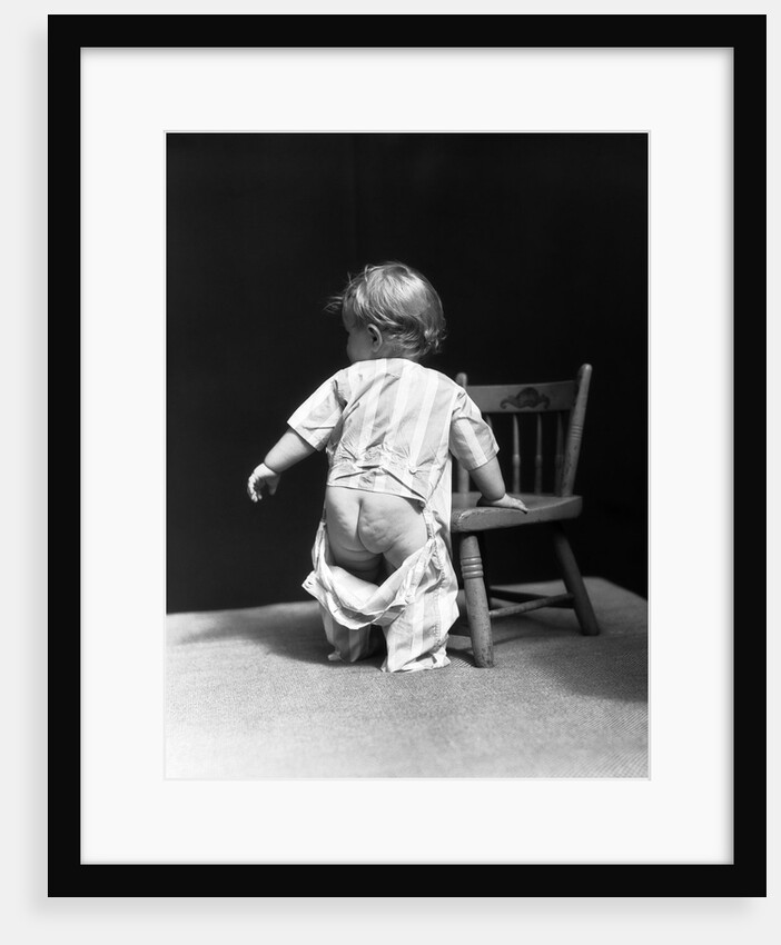 1930s Baby Wearing Drop Seat Pajamas Showing Bare Bottom Leaning On Chair by Anonymous