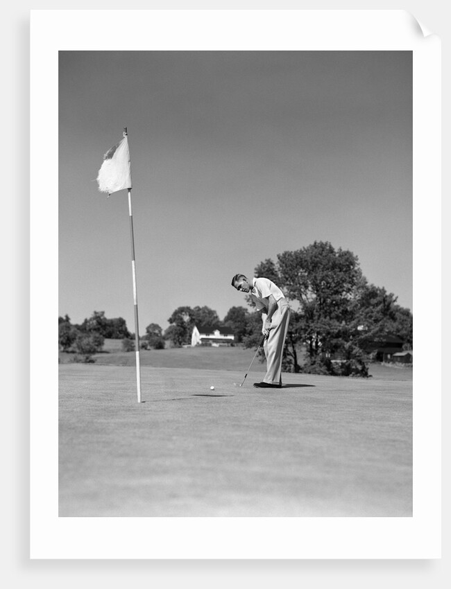 1950s Man Playing Golf Putting Golf Ball On Green To Flag And Cup Outdoor by Anonymous