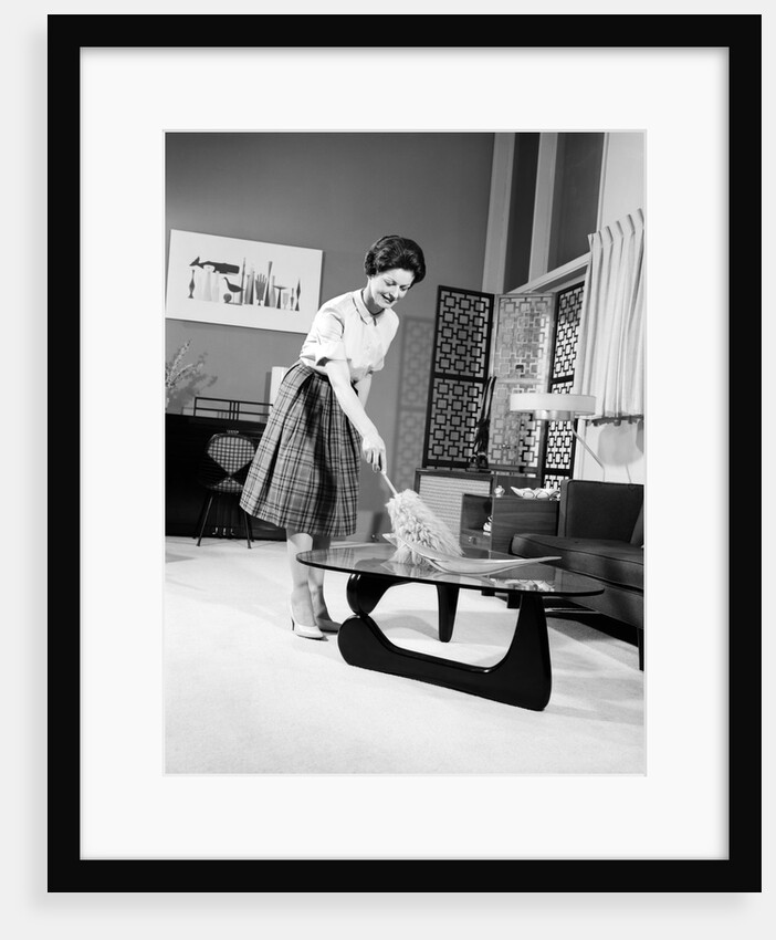 1950s 1960s Woman Wearing A White Blouse & Plaid Skirt Dusting With A Feather Duster A Glass Top Coffee Table by Anonymous