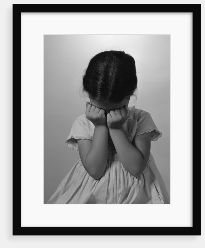1960s Sad Little Girl Sitting Hands On Face Crying by Anonymous