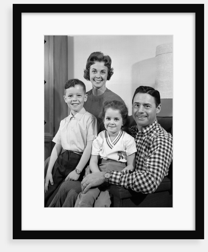 1960s Family Sitting On Couch Smiling Looking At Camera by Anonymous