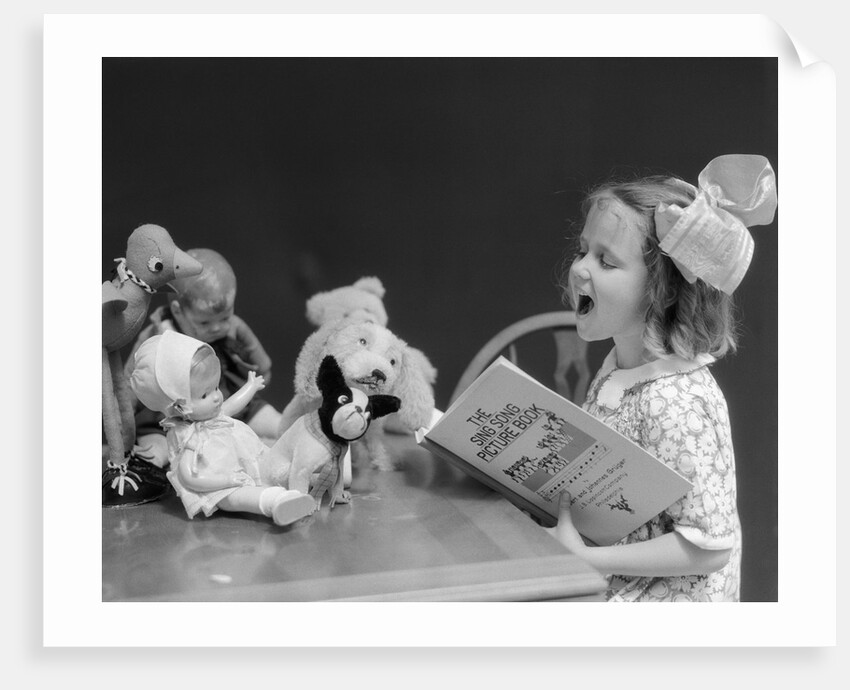 1930s Enthusiastic Little Girl Big Bow Ribbon In Her Hair Singing To Assembled Group Of Dolls Toys And Stuffed Animals by Anonymous