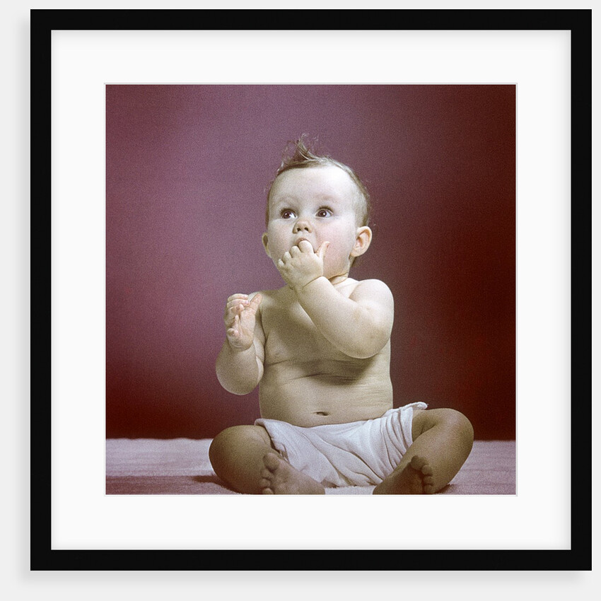 1940s 1950s Baby Diaper Sitting Looking Up Fingers In Mouth by Anonymous