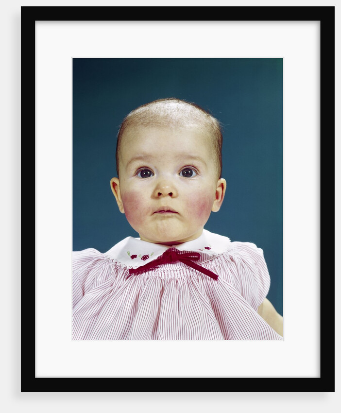 1960s Portrait Baby Girl Silly Facial Expression Red Bow At Collar Looking At Camera by Anonymous