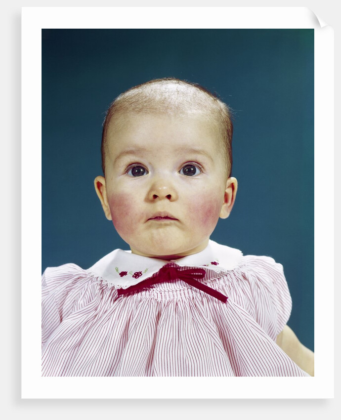 1960s Portrait Baby Girl Silly Facial Expression Red Bow At Collar Looking At Camera by Anonymous