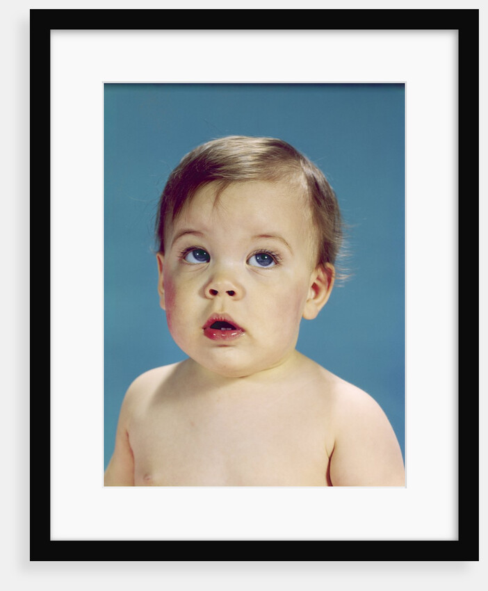 1960s Baby With Uncertain Facial Expression Deep Blue Eyes Looking Guilty Up And To The Side by Anonymous