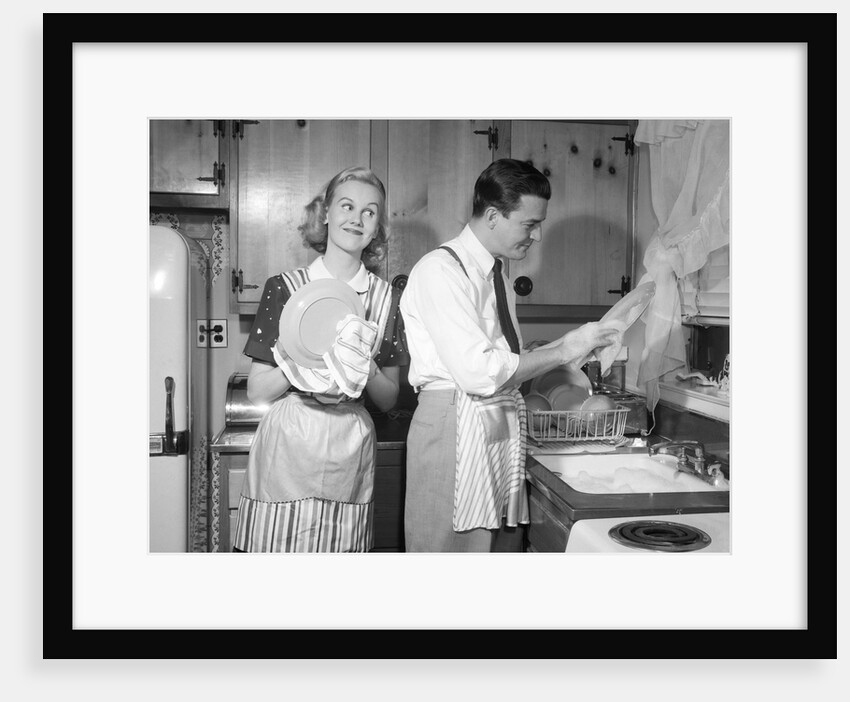 1950s smiling couple washing the dishes together by Anonymous