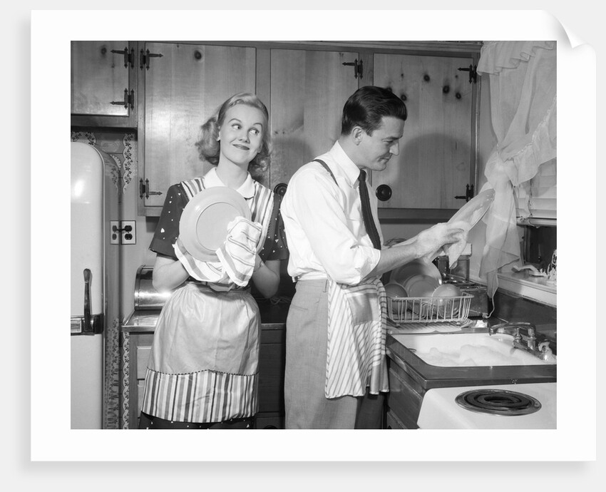 1950s smiling couple washing the dishes together by Anonymous