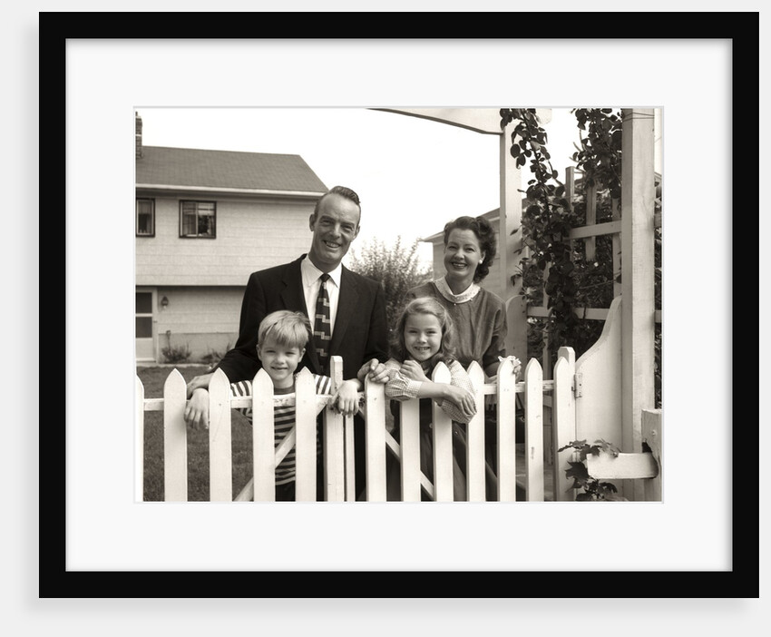 1950s family of four behind picket fence by Anonymous