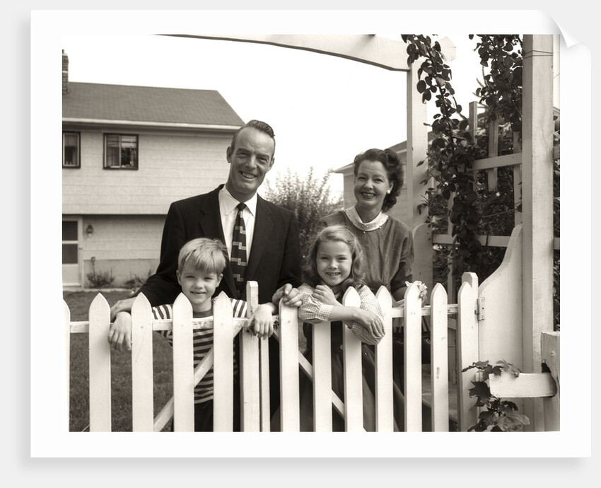 1950s family of four behind picket fence by Anonymous