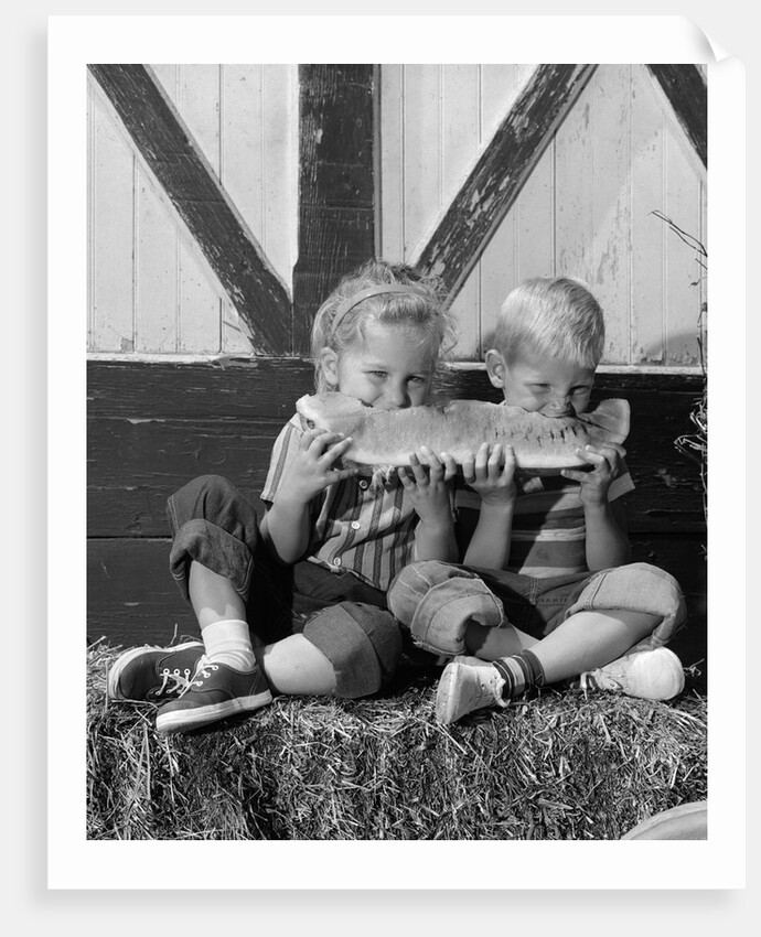1960s boy and girl sharing a slice of watermelon by Anonymous