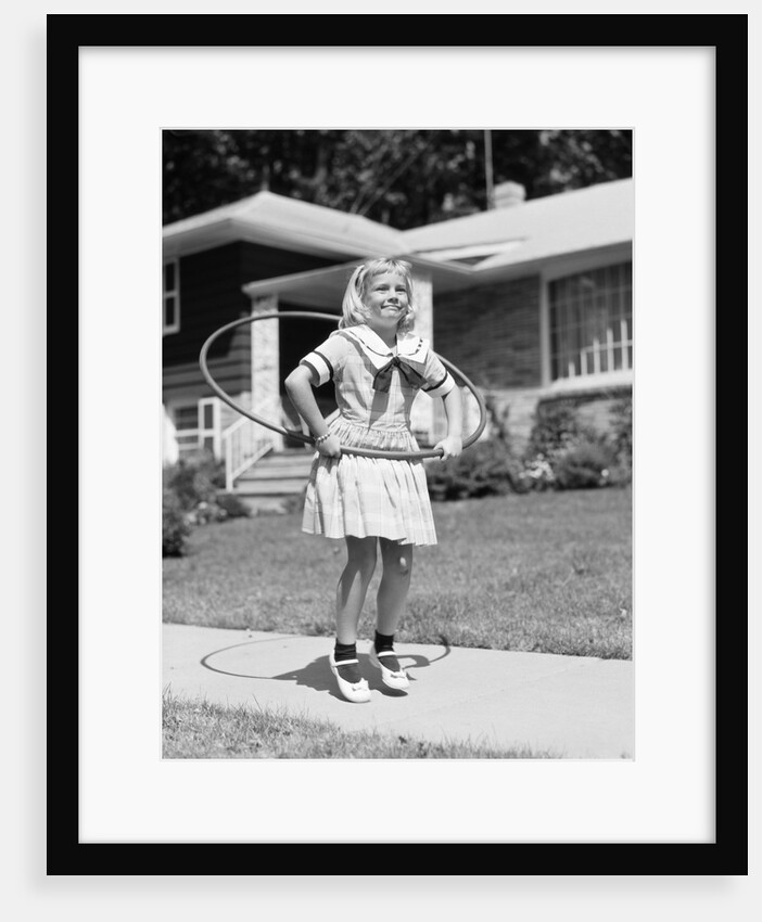 1950s girl on suburban sidewalk playing with a hula hoop by Anonymous