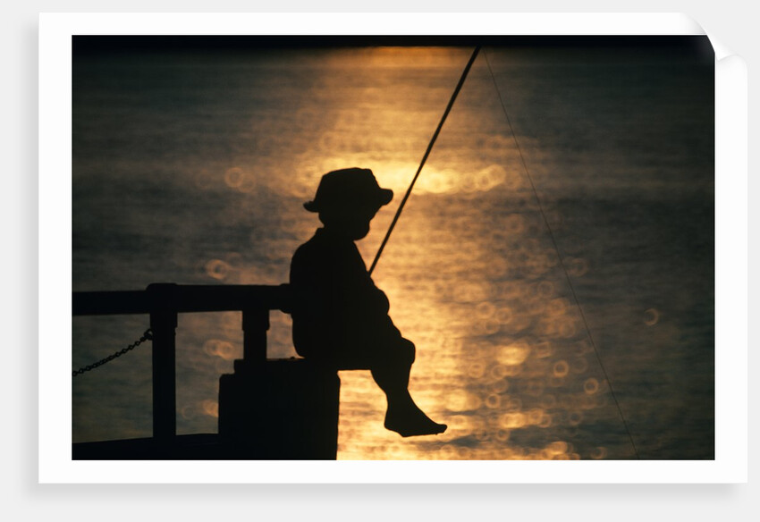 Silhouette of child fishing off a dock at sunset by Anonymous