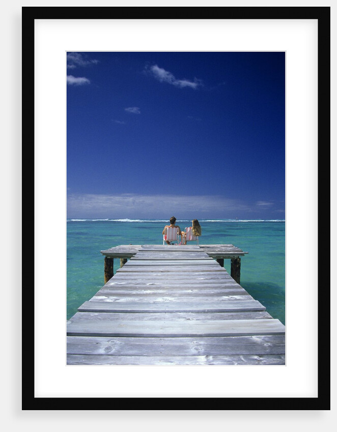 couple Sitting On A Pier In An Ocean Lagoon by Anonymous