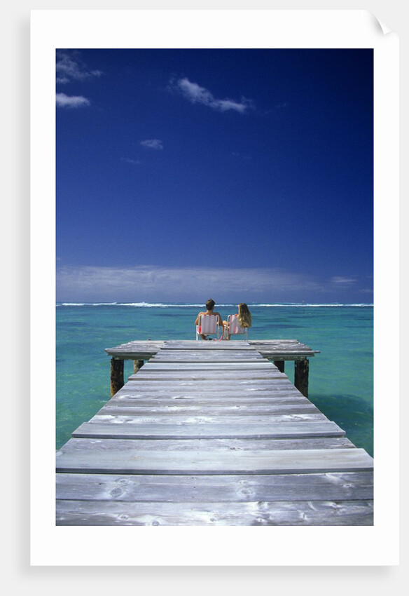 couple Sitting On A Pier In An Ocean Lagoon by Anonymous