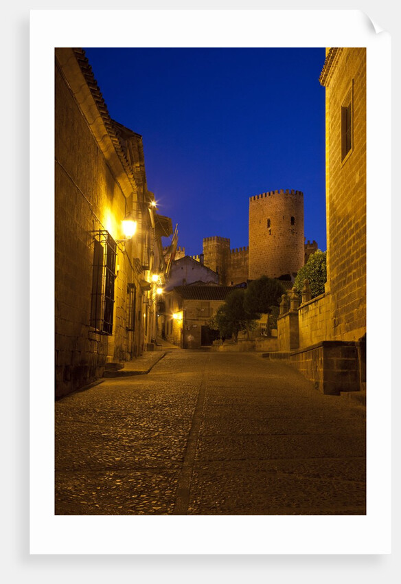 Streets of Banos de la Encina at night with the Moorish castle, named Burgalimar Castle, in the back by Anonymous