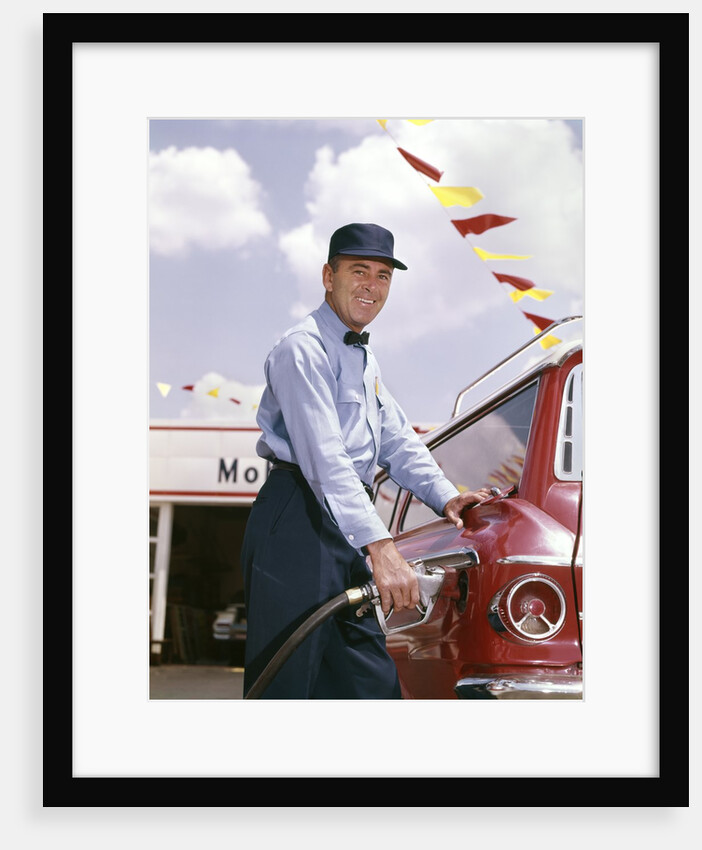 1950s smiling service station attendant pumping gas by Anonymous